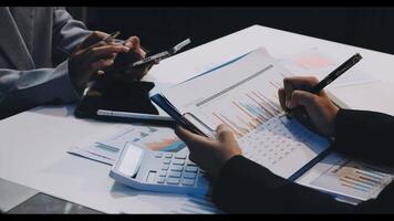 Business people working on a document with a calculator video