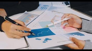 Business people working on papers with graphs and papers video