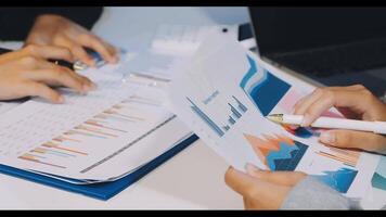 Business people working on papers with graphs and charts video