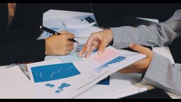 Business people working on papers with graphs and papers video