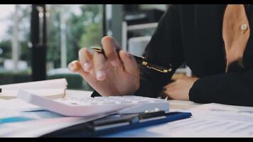 A person is using a calculator and pen to write on paper video
