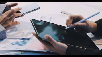 Business people using tablets and phones to work on documents video
