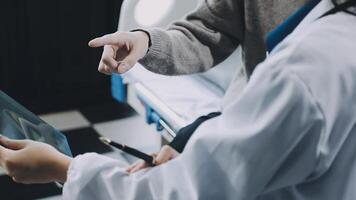A doctor is pointing at a tablet computer video