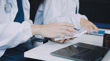 Two doctors using a laptop and tablet video