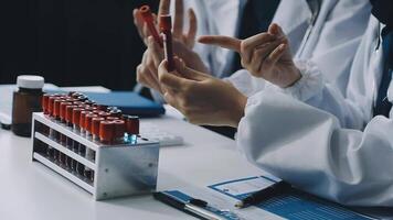 A group of doctors in lab coats are working on a computer video
