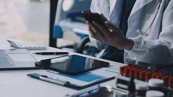 A doctor is using a cell phone while sitting at a desk video