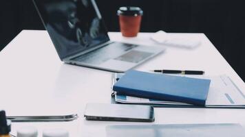 A laptop and a notebook are sitting on a desk video