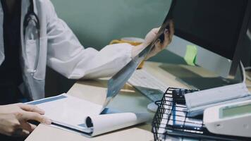 A doctor is working on a computer while holding a clipboard video