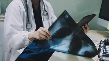 A doctor is looking at an x - ray image on a tablet video