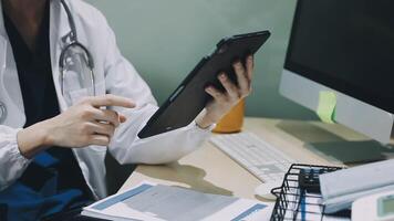 A doctor is using a tablet computer at his desk video