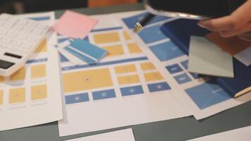 A person is using a calculator and a phone to make a design video