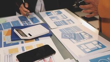 Business people working on a table with various papers and calculators video