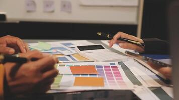 A group of people working on a project with colorful papers video