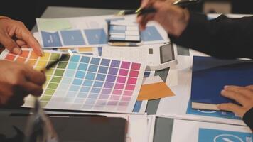 A group of people working on a project with colorful papers video