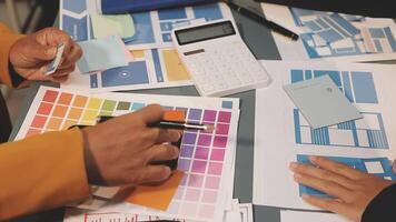 A person is working on a design project with a calculator and other papers video