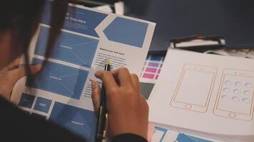 A person is working on a design project with a laptop video