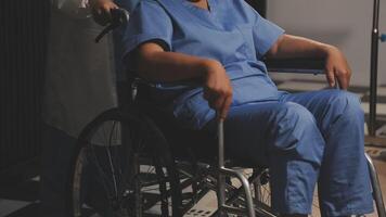 A woman in a wheelchair is being helped by a doctor video