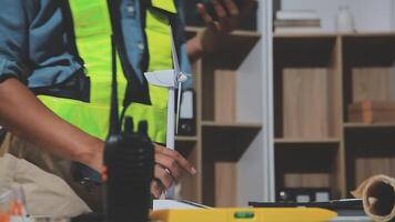 A man in a safety vest is working on a computer video