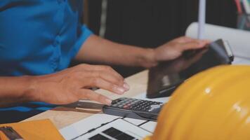 A person using a calculator and a hardhat video