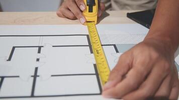 A person is using a ruler to measure a blueprint video