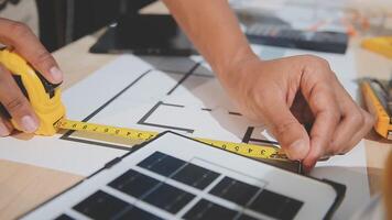 A person is using a tape measure to measure a blueprint video