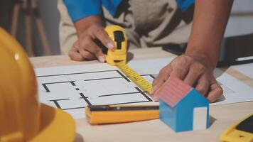 A person is using a tape measure to measure a house video