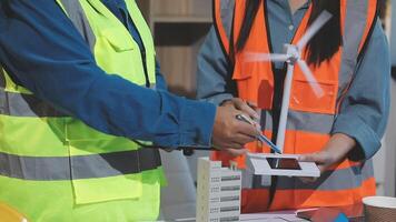 Two people in safety vests working on a wind turbine video