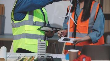 Two people in safety vests working on a wind turbine video