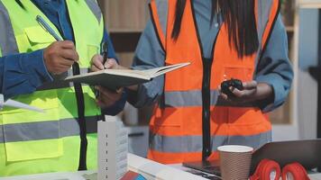 Two people in safety vests are working on a project video