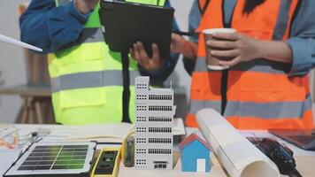 dois pessoas dentro segurança coletes em pé Próximo para uma modelo do uma construção video
