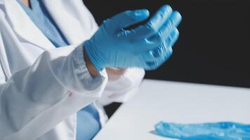 A person in a lab coat is holding a blue glove video