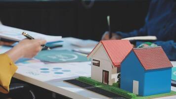 A person is working on a house model with a pen video