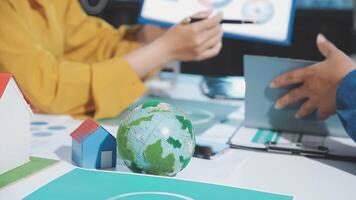Business people working on a project with a globe and house video