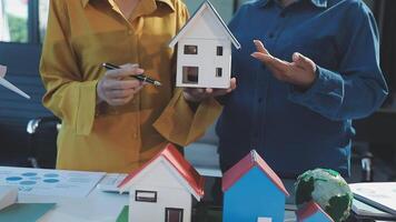 Two people holding paper houses and a piece of paper video