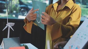 A woman holding a paper with a wind turbine on it video