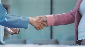 Two people shaking hands in an office setting video