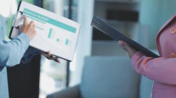 Two people in business attire holding a clipboard video