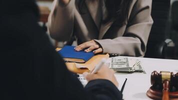 A woman is holding a book and money in front of a desk video