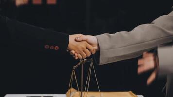 Two business people shaking hands over a table with scales video