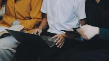 Three people sitting on a couch with laptops video