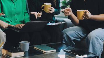 A group of people sitting on a couch with laptops and coffee cups video