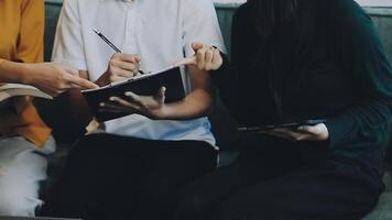 Three people sitting on a couch with a notebook video