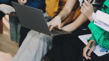 A group of people sitting on a couch with laptops video