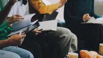 A group of people sitting around a table with papers video