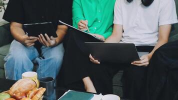 Three people sitting on a couch with laptops video