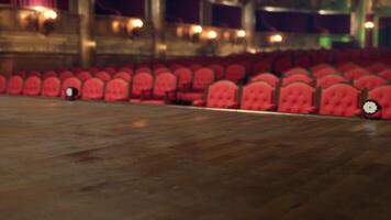 An empty, historic opera house stage with red velvet seats in the audience video