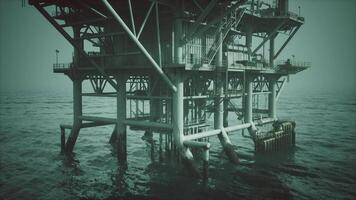 Old oil platform standing tall in the ocean during twilight hour video