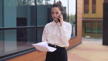 Beautiful business girl is happy to throw documents up after she was informed by good news. slow motion. video