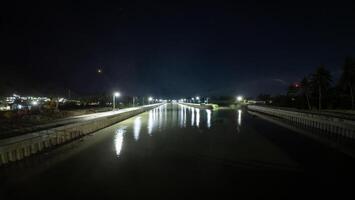 Night view of the bridge over the river with reflection in the water photo