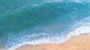 Sea wave on sand beach background. Top view of ocean wave on sandy beach photo